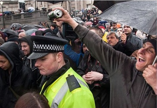 Demonstranten lustig - Mit Bier begossener Polizist