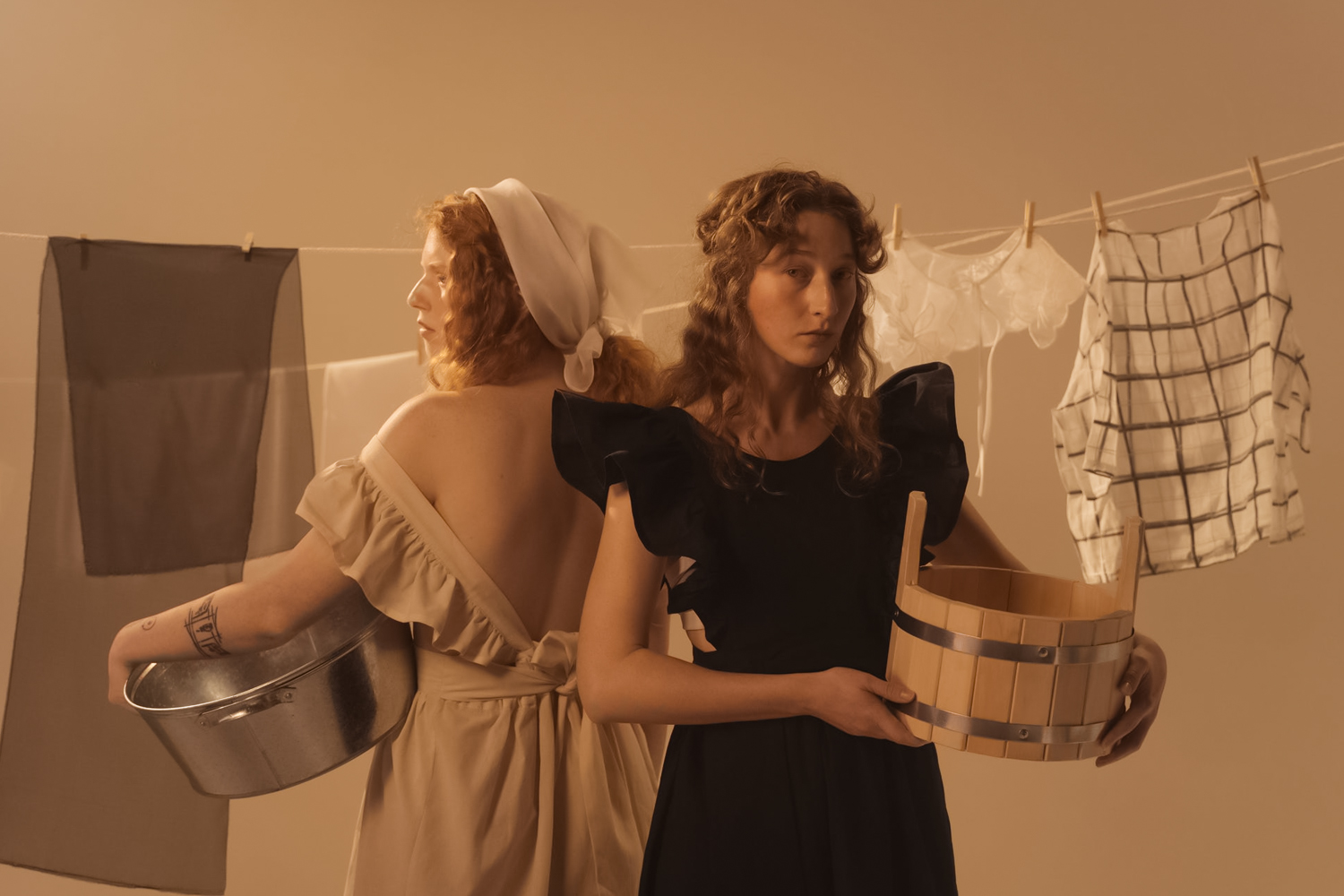 two women in vintage clothing do laundry