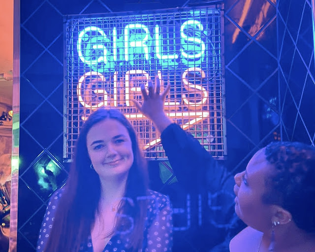 Girls in front of neon sign at Simmons Bar London