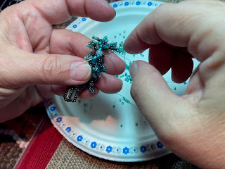 working on beaded plant in hand