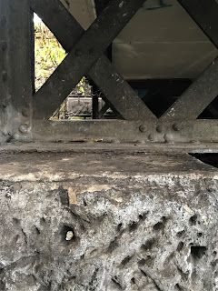 A picture of a small ceramic skull (Skulferatu 63) in the stone part of one of the support pillars for the Newhaven Station building.  Photograph by Kevin Nosferatu for the Skulferatu Project