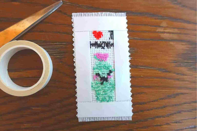 Stick double-sided tape on the back side of the stitched work