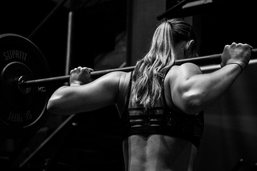 A muscled fitness woman lifting weight in the gym to lose weight
