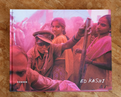 color image of book cover for Abandoned Moments by Ed Kashi. The cover image shows people celebrating the Ganpati Festival to the Lord Ganesh, India
