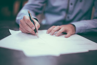 A man writing on paper what he needs to start a business