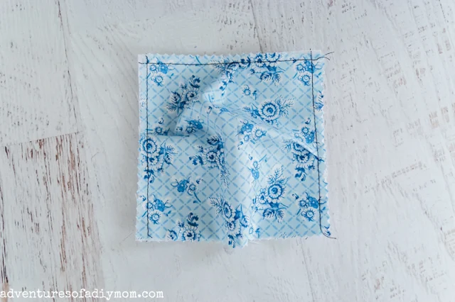 blue fabric pleated and sewn to a smaller square of fabric to make a puff quilt