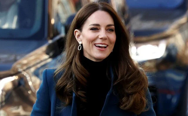 Kate Middleton wore her navy coat. Kate wore a sleek black polo neck top, and black trousers from Jigsaw. Accessorize gold earrings