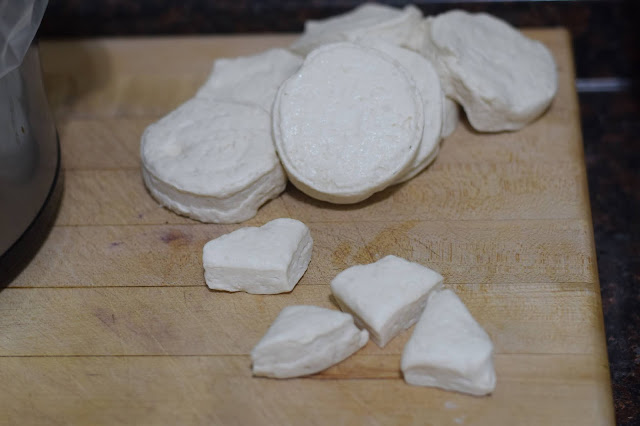 Cutting the canned biscuits into sized pieces.