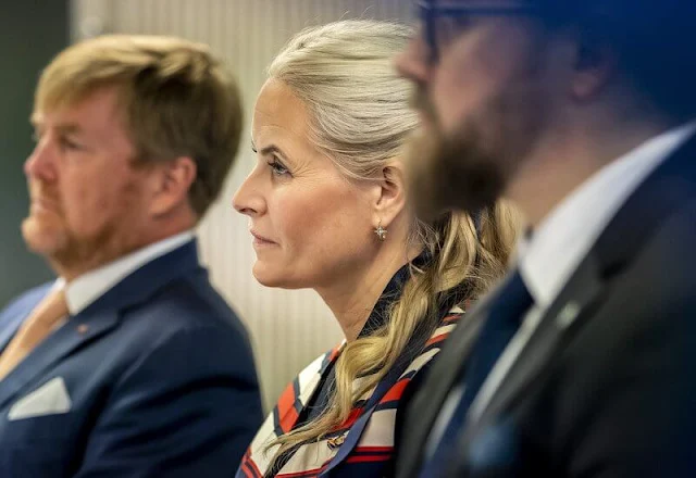 Crown Princess Mette Marit wore a satin stripe sleeveless trench coat by Tome. Queen Maxima wore a navy and beige dress by Jan Taminiau