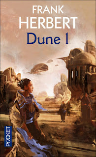 première de couverture Dune édition 2005 montre un paysage jaune sable et une femme en premier plan qui regarde vers la droite, des hommes en arrière plan et un décor de village de sable, de vaisseaux spatiaux
