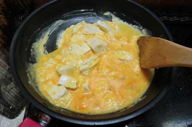 フライパンにごま油、豆腐をちぎって入れ、軽く表面に焼き色をつけます。  溶き卵を加え、木べらで大きくかき混ぜながら大粒の半熟炒り卵を作ります。