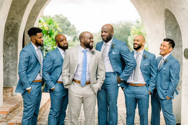 groom in grey suit with groomsmen in blue suits