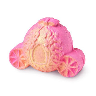 A carriage shaped rose gold glitter covered bath bomb on a bright background