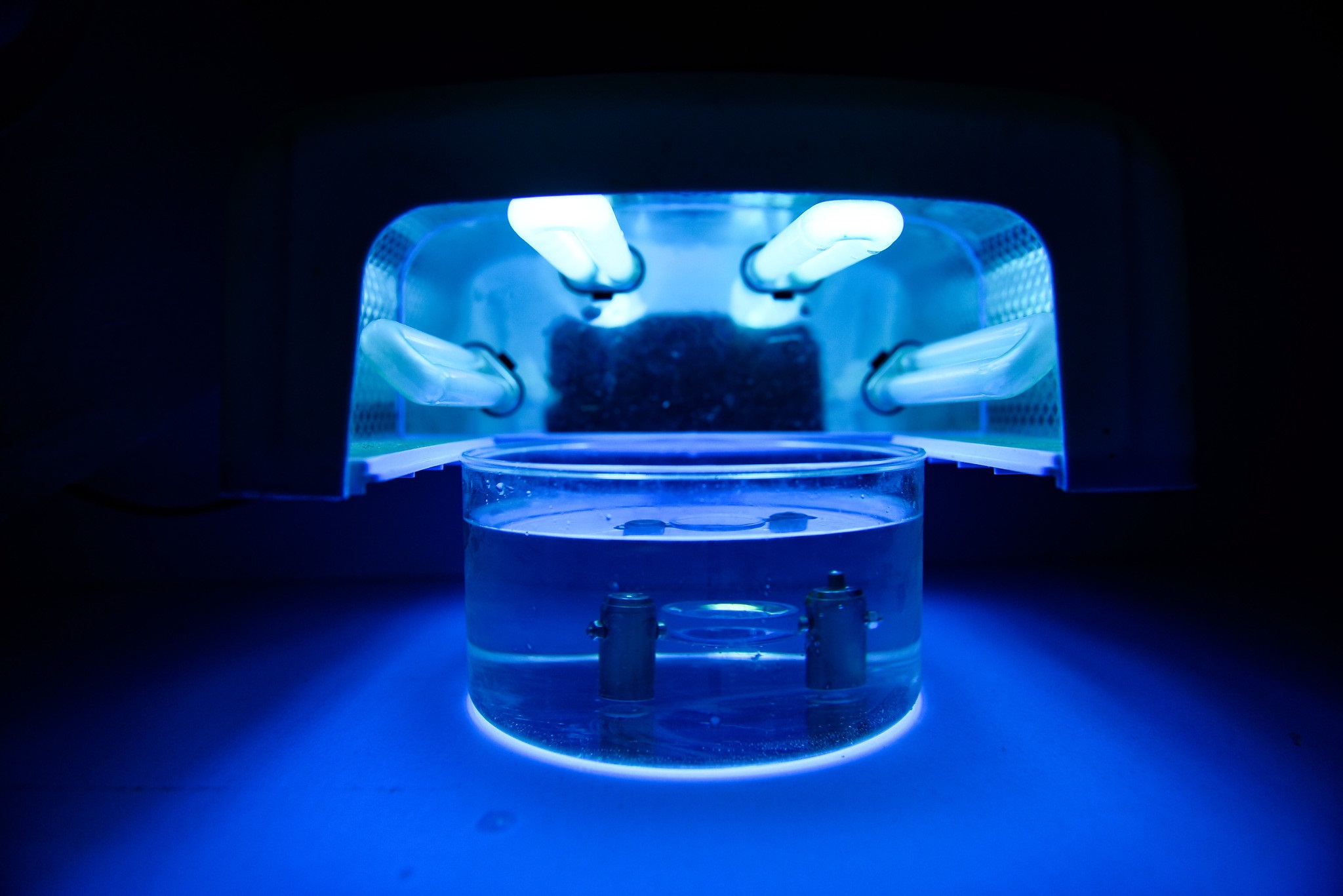Оптическая линза из полимерного материала под ультрафиолетовыми лампами