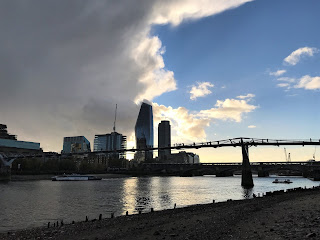 A picture from the foreshore of the River Thames showing the Millennium bridge crossing the river and various high rise office buildings in the background.  Photograph by Kevin Nosferatu for the Skulferatu Project