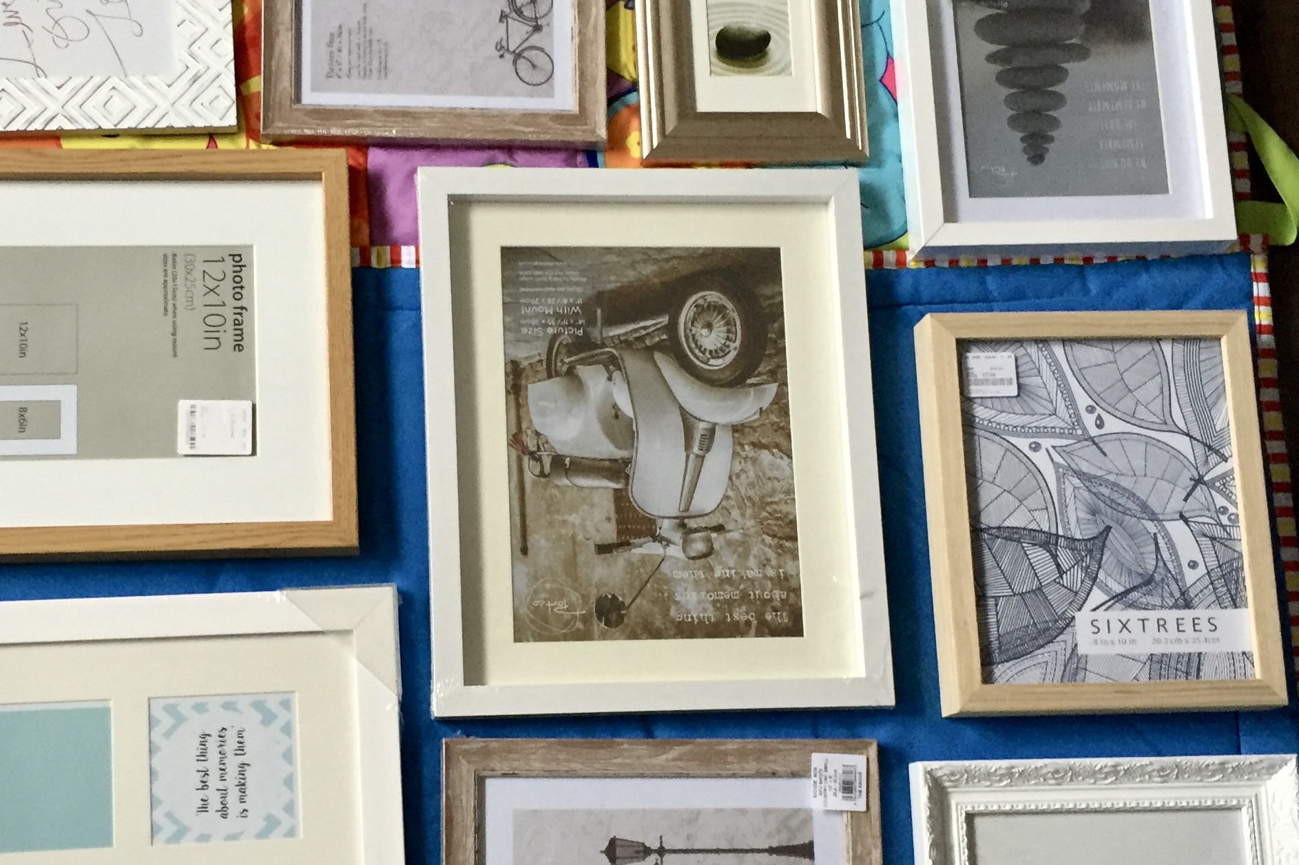 A collage wall of picture frames arranged on the floor