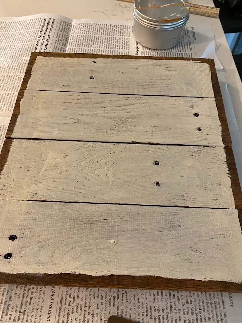 Photo of a wooden slatted photo holder being painted off white.