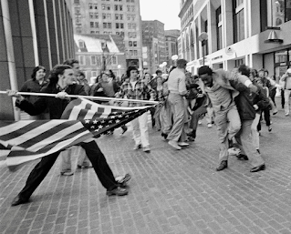 In this photograph titled "The Soiling of Old Glory," Joseph Rakes assaults lawyer and civil rights activist Ted Landsmark with a flagpole bearing the American flag