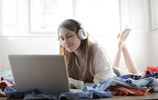 girl on bed listening to a podcast