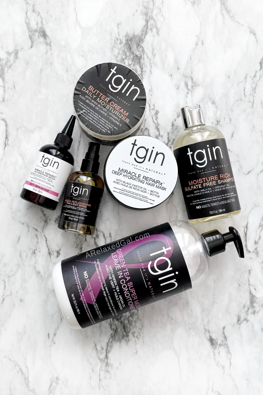 tgin shampoo, conditioner, moisturizers sitting on a marble counter.