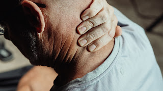 a man holding his neck in pain | Best chiropractor Ann Arbor
