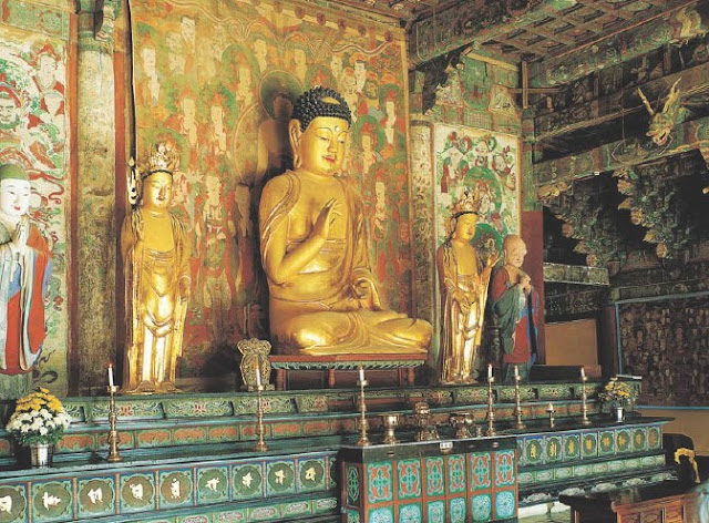 main hall enshrines a gilt wooden Buddha triad flanked by earthen images of the two disciples of the Historic Buddha