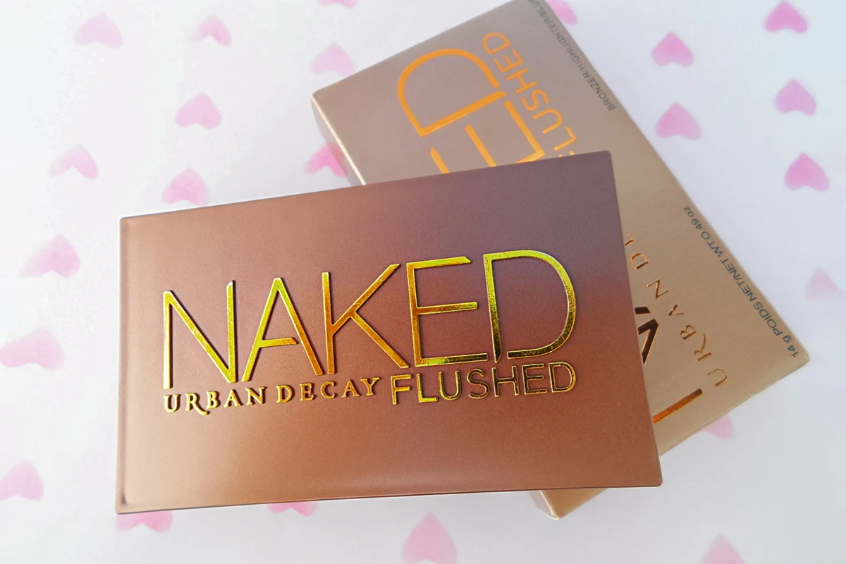 a close-up picture of an opened naked flushed palette by urban decay on a plain background