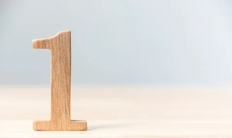 Wood carving of the number one on a table