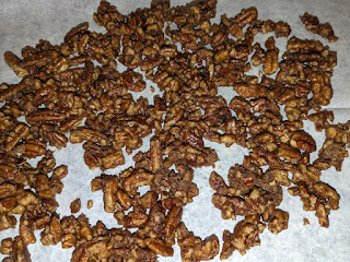 softly candied pecans drying on a sheet of parchment paper