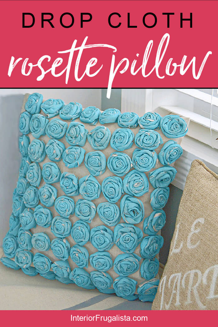 How to make fabric roses with an inexpensive drop cloth painted a pretty turquoise and sew a simple envelope style pillow cover for a bedroom. #rosettepillowdiy #dropclothrosettepillow #diypillowcover