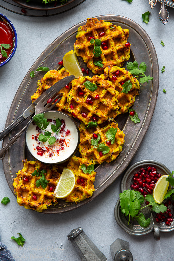 savoury semolina waffles with pumpkin served in an oval tray topped with cilantro