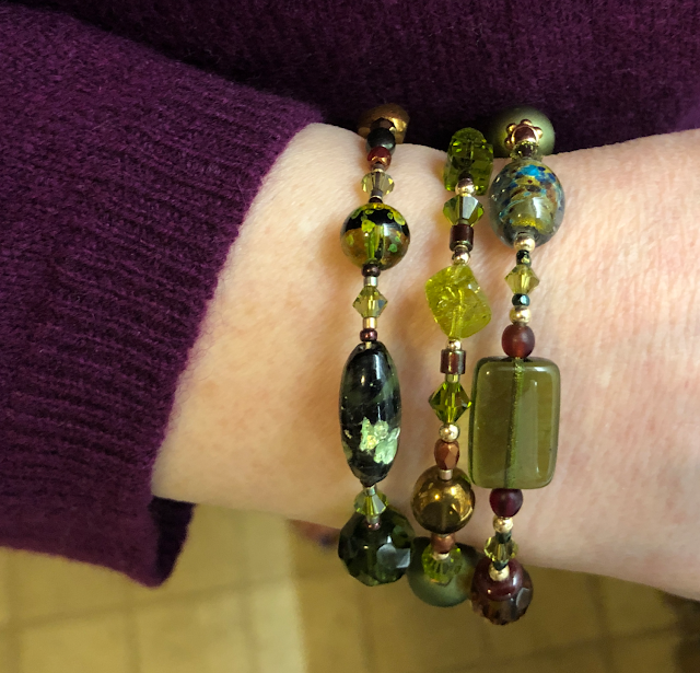 Close-up photo of finished beaded coil wrap bracelet being worn on woman's wrist