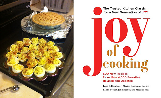 G’s deviled eggs in her carnival glass egg dish, with an apple pie in the background, next to the cover of “Joy of Cooking.”