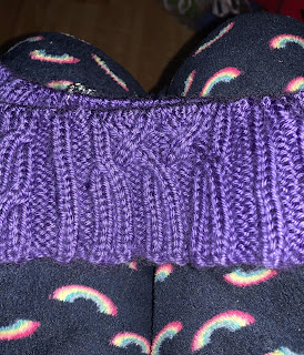 A focused section of knitting with a handful of cabled twists.