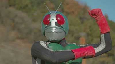 Kamen Rider (superhero with a bug-like mask) flexes his bicep