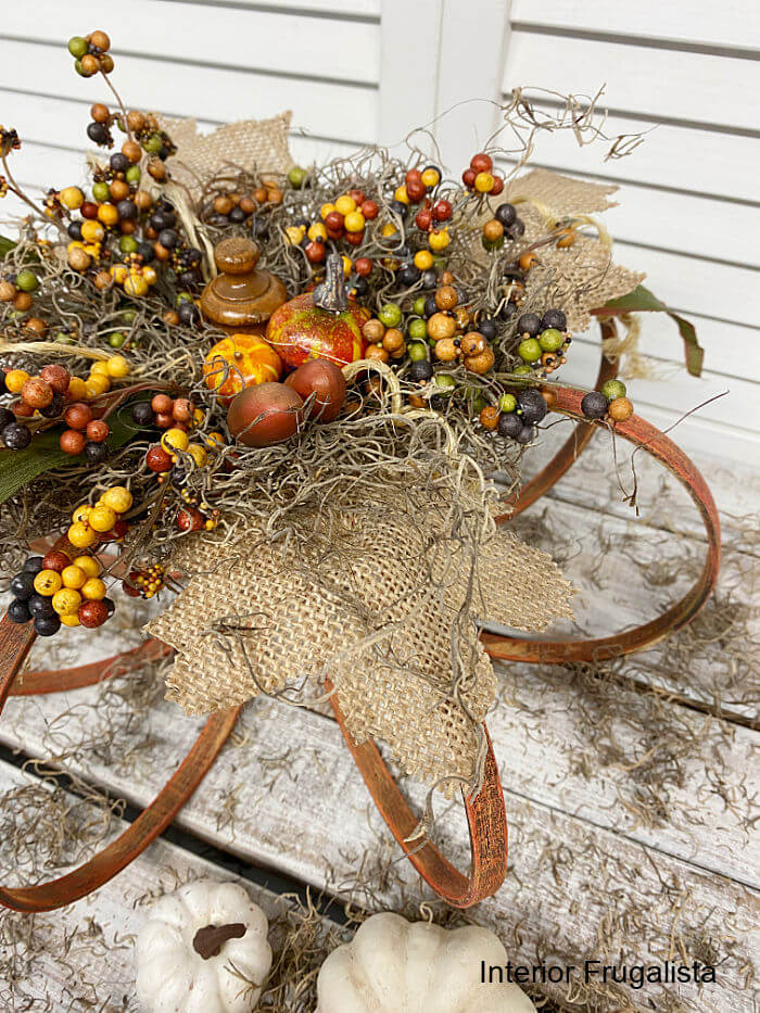 How to make a rustic DIY fall pumpkin with embroidery hoops and embellished with Spanish moss and pretty fall berry clusters from the dollar store.