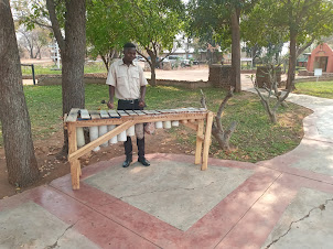 Musician playing a local instrument at Batoka Aerodrome ground.