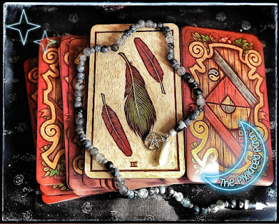 3 of Feathers cardfrom the Labyrinth Tarot, in the reversed position.