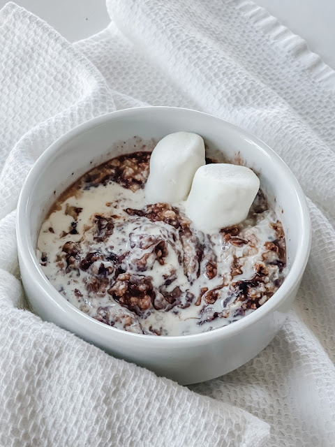 Oatmeal in a white round bowl with swirls of hot chocolate powder