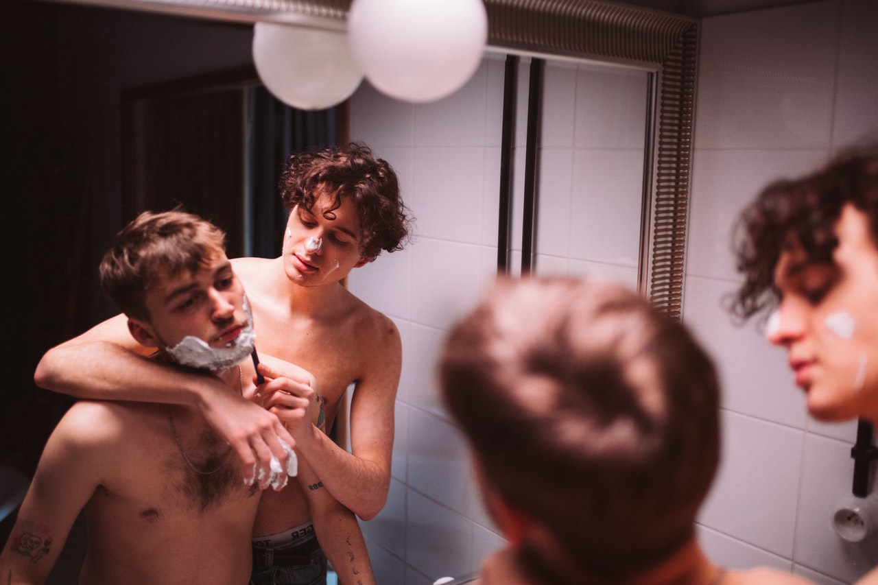 Two teenage boys semi-naked shaving beard for the first time. two friends shaving beard.