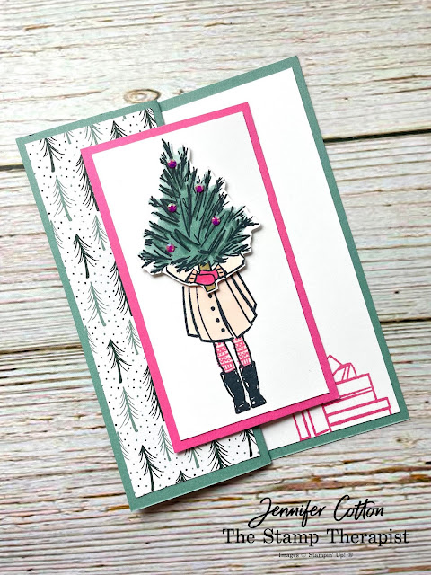 Christmas card using Stampin' Up! Delivering Cheer stamp set.  Z fold (fold the front 1/2 back to the left and then attach an image to the flap).  Girl in coat holding a Christmas tree.  When you open it says You Warm My Heart (Encircled in Warmth stamp set) in Polished PInk.  Card base is Soft Sucuclent.  Girl is colored with Stamin' Blends: petal pink, polished pink, evening evergreen, soft succulent.  Jennifer Cotton.  More details on video on blog.