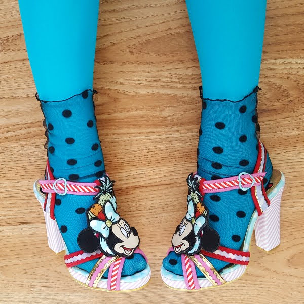 feet on wooden floor wearing polka dot tulle socks and Minnie Mouse sandals