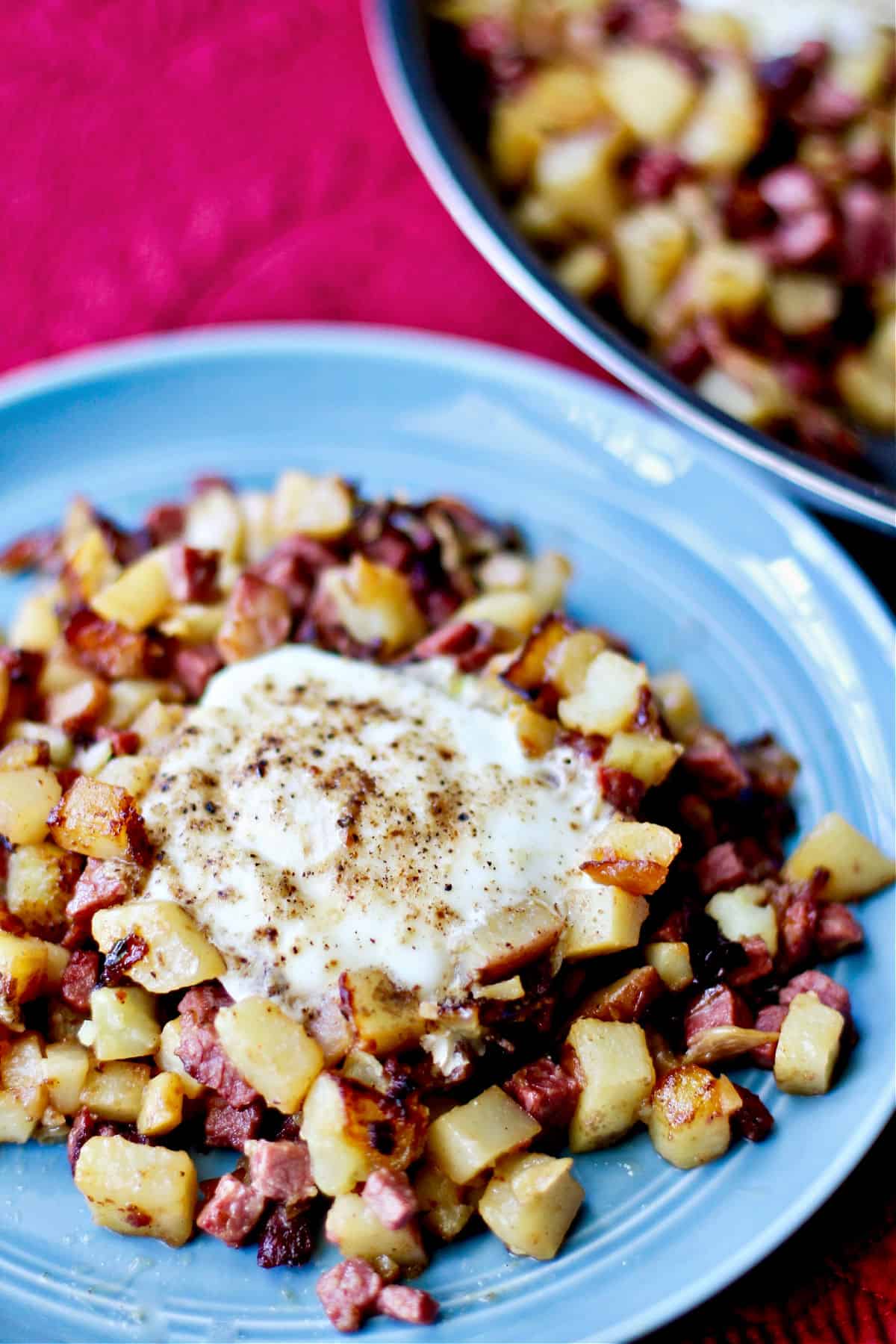 Corned Beef Hash with Yukon Gold Potatoes and Chiles with eggs on a plate.