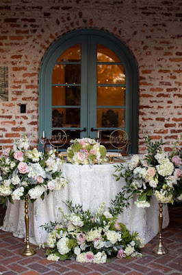 bride and groom sweetheart table with flowers and white linen