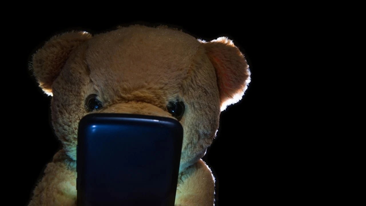 Lonely teddy bear addicted to his cellphone.