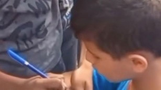Children in Palestine Mark Themselves for Identification Amidst Airstrikes