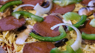 Vegan pepperoni, green pepper, mushroom and onion pizza before going in the oven