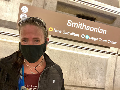 Selfie of me in a mask in front of a horizontal Smithsonian Metro sign inside a station