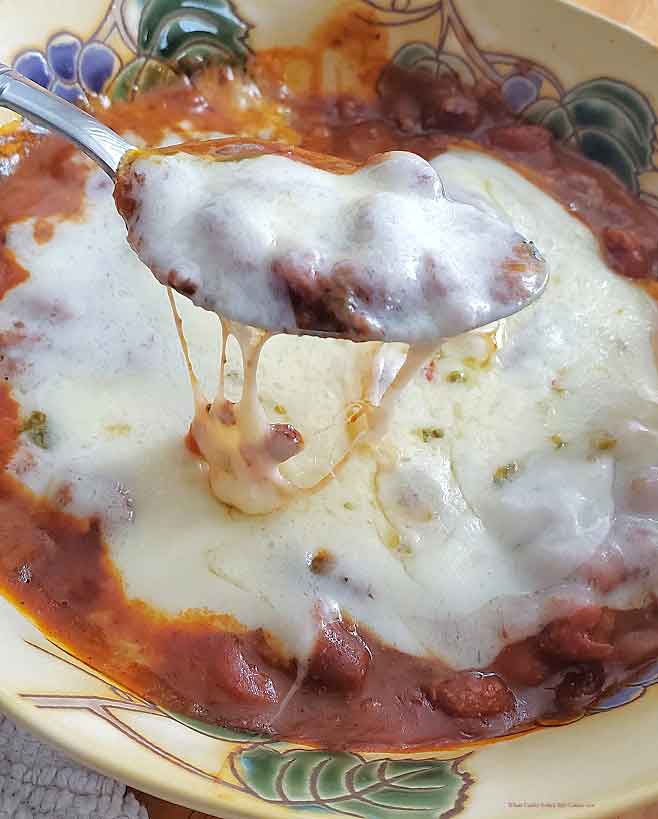 this is a big bowl of chili loaded with melted cheese