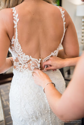 bride getting dress zipped up